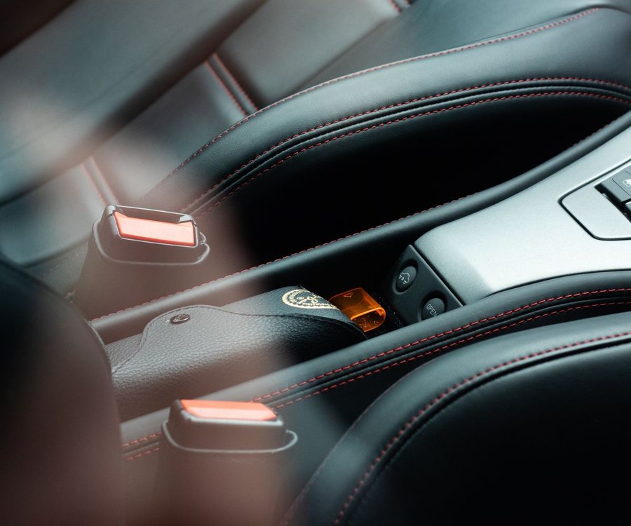 Black leather car seat with red stitching (illustrative stock photo)